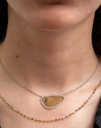 Necklace with a pendant worn by a person