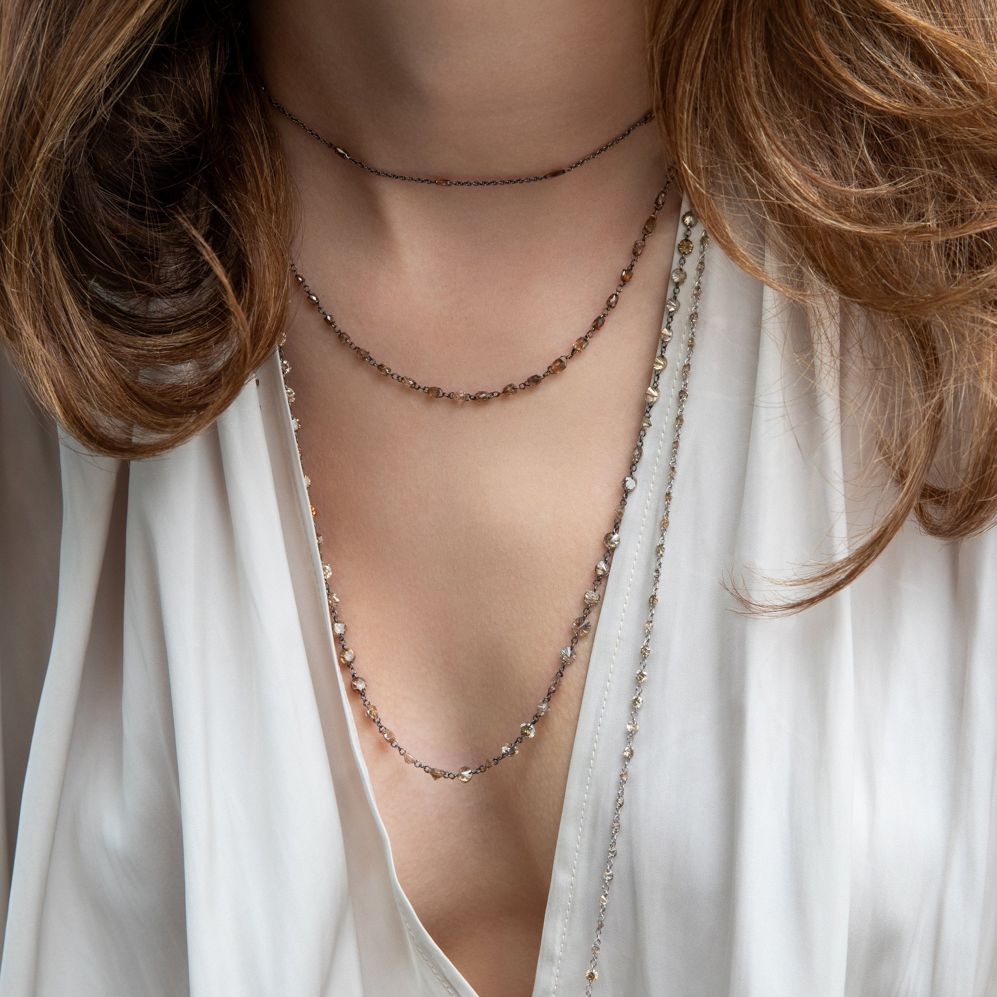 layered brown diamond necklaces on model